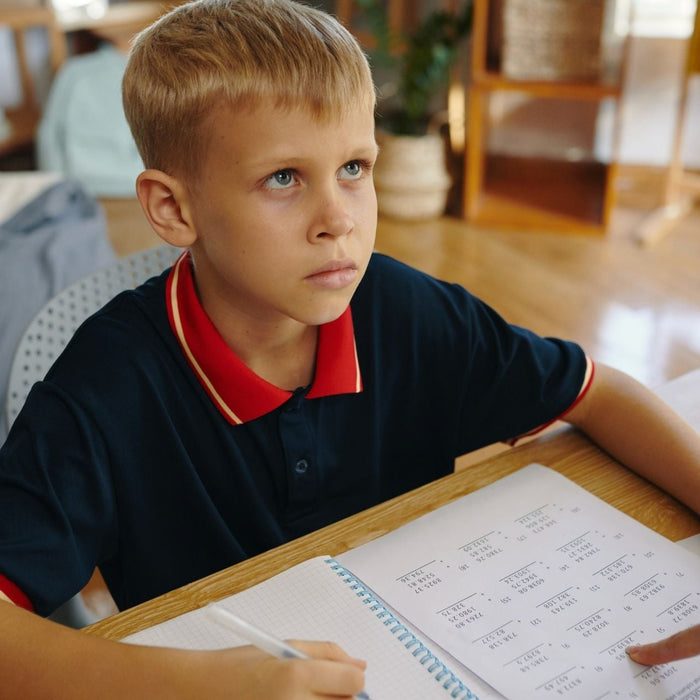 Child focusing on homework with adult support.
