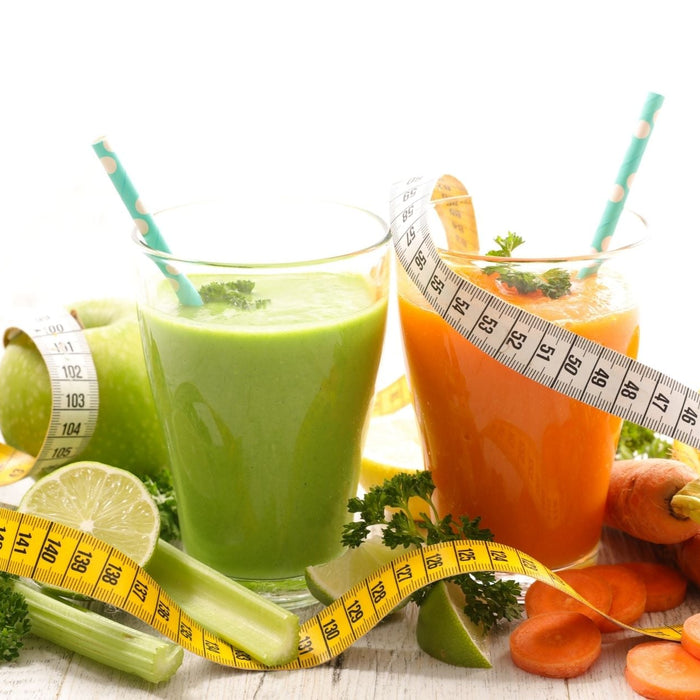 Detox smoothies with fresh fruits, vegetables, and measuring tape for weight loss