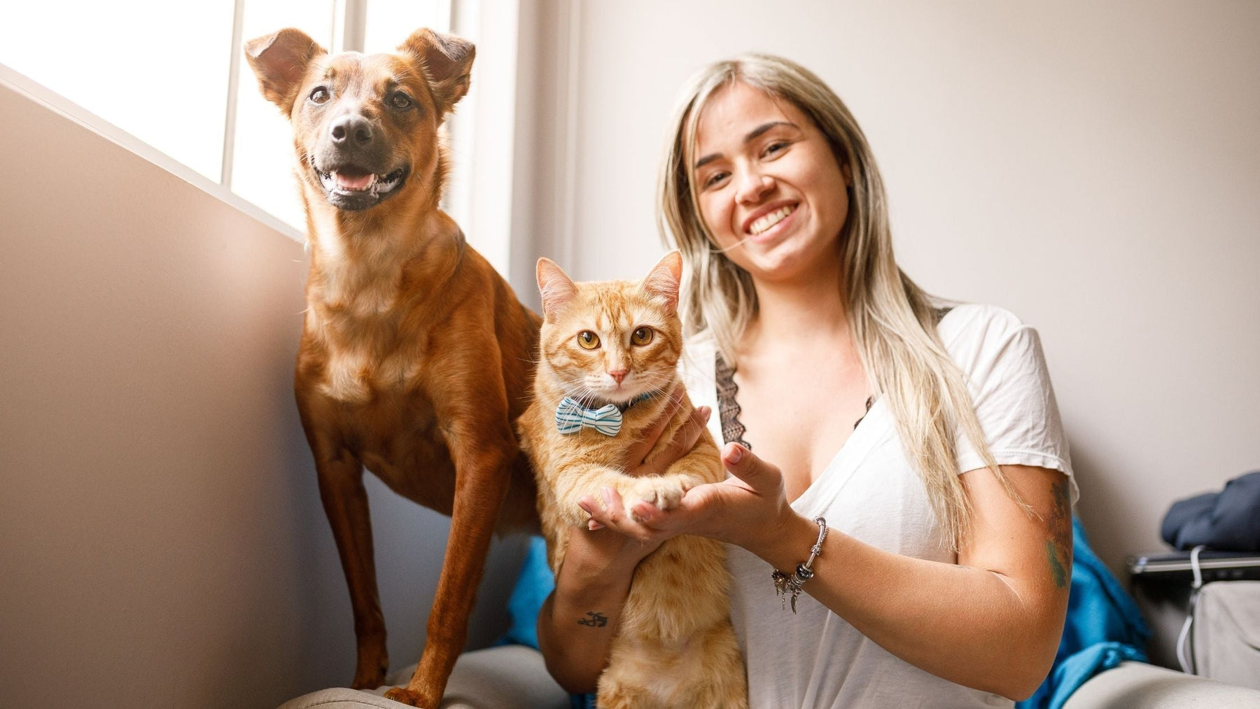 Woman with healthy dog and cat supporting pet immune health naturally