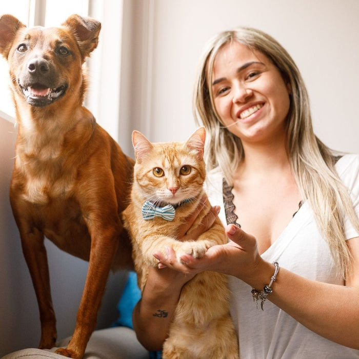 Woman with healthy dog and cat supporting pet immune health naturally